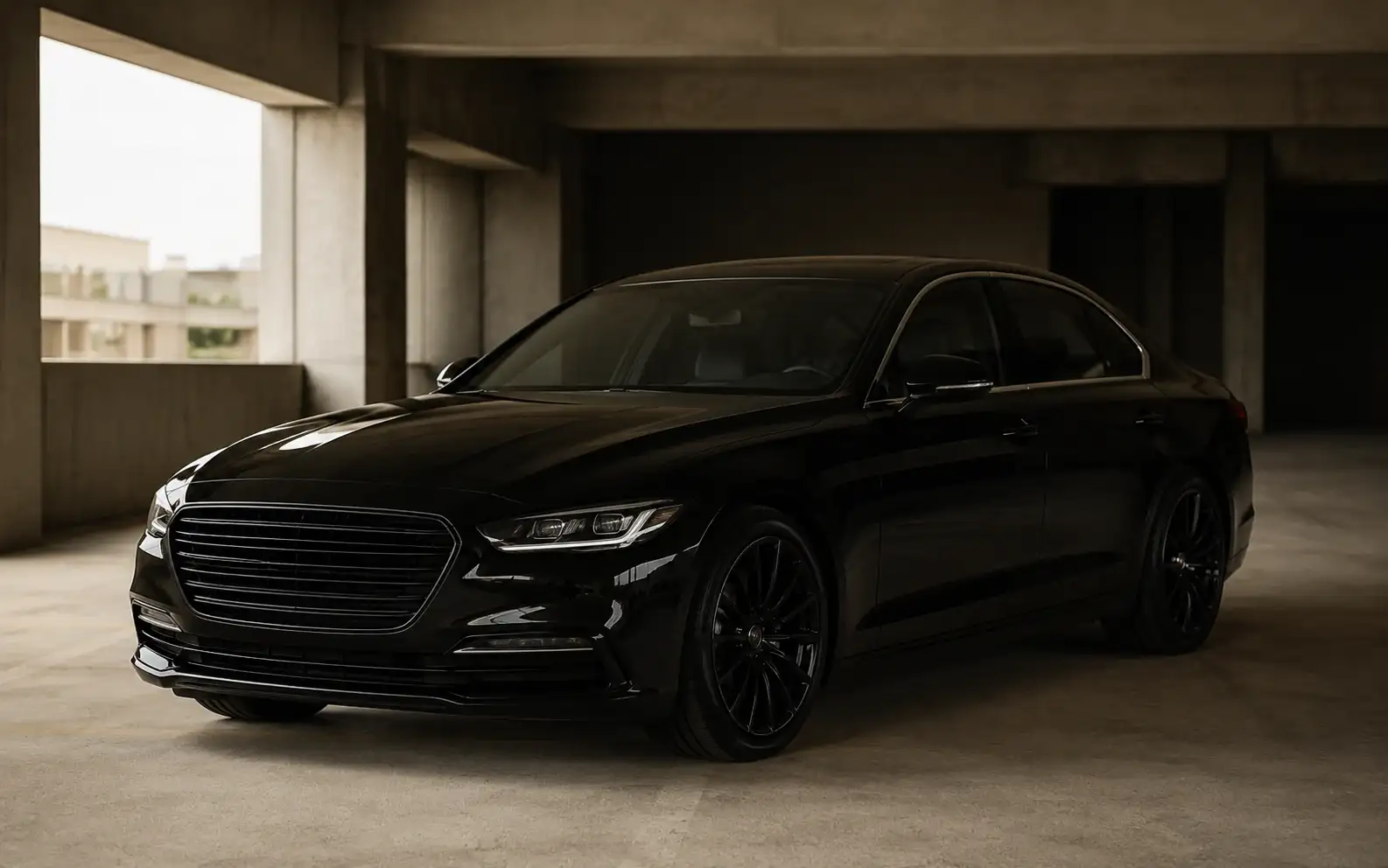 A black executive sedan in a concrete parking structure, lit by soft daylight.