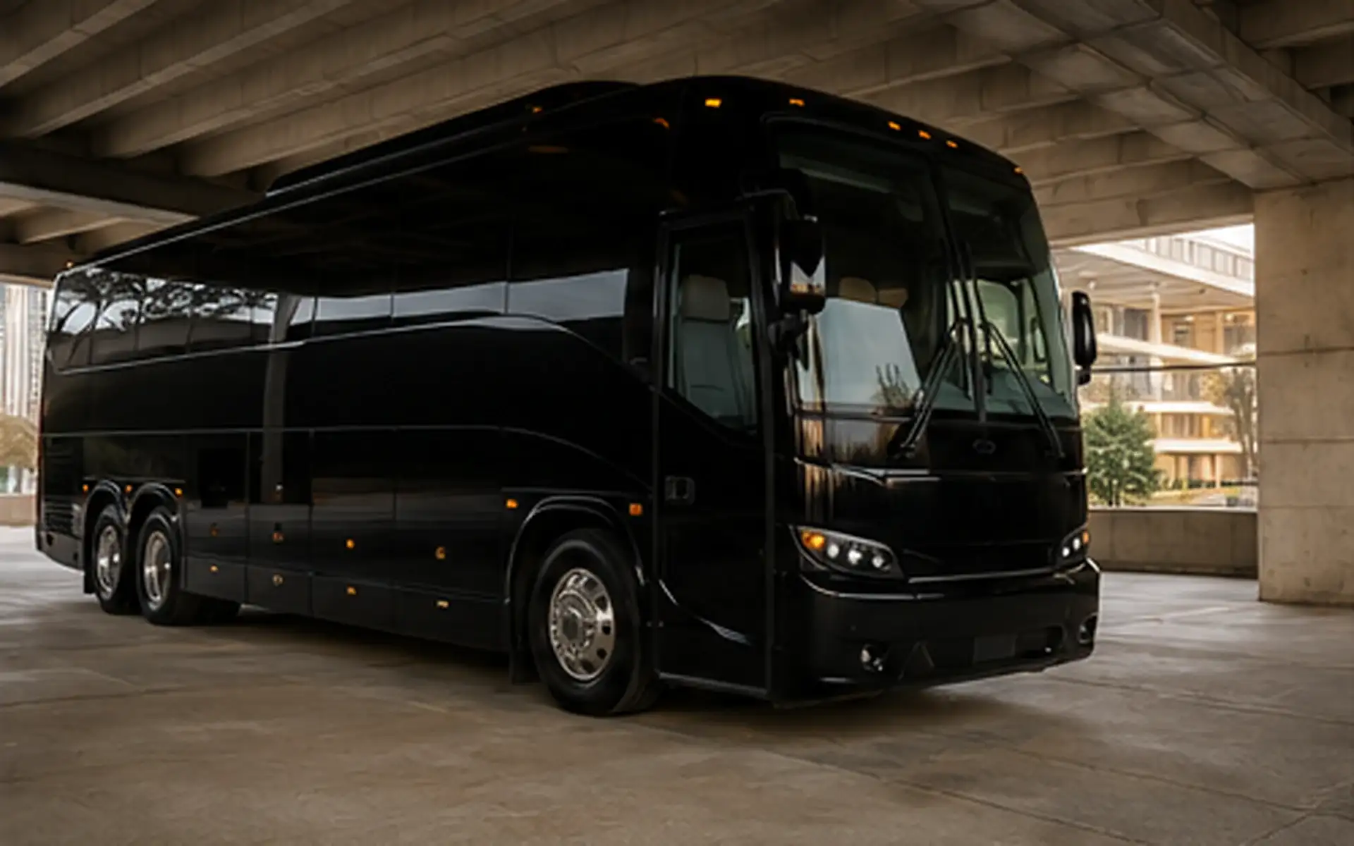 A black executive party coach parked under a concrete portico.